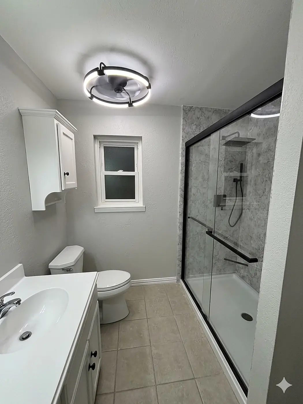 Tub-to-Shower Conversion — tub-to-shower conversion with soft grey stone panels, a black-framed sliding glass door, low-threshold base and matching grab bar, installed by Revive Bath Solutions in Longview, TX