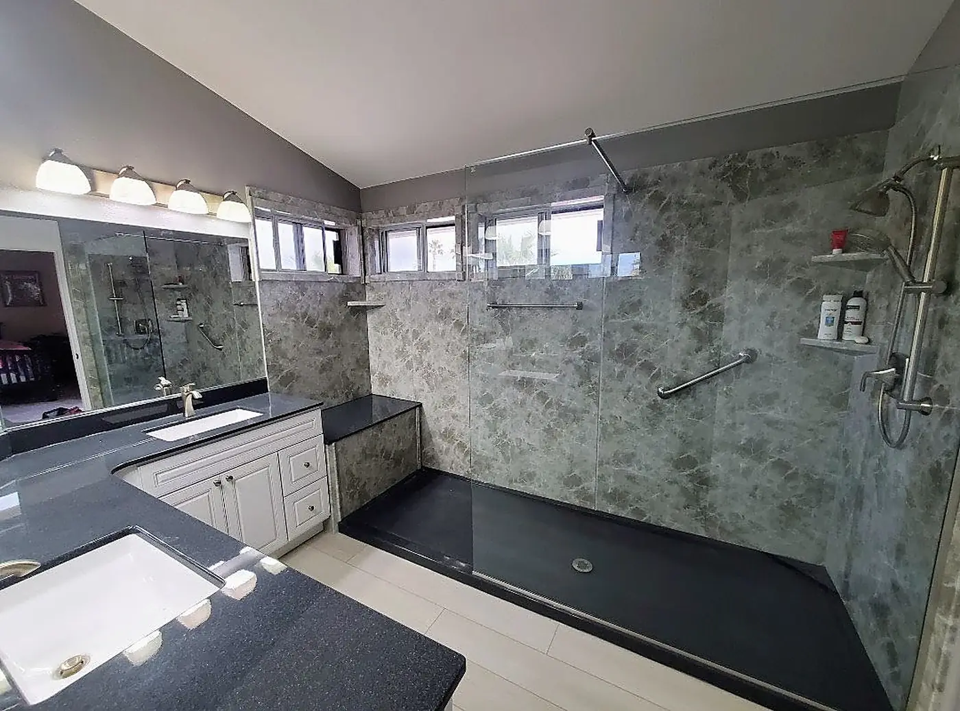 Green Marble Walk-In Shower — oversized walk-in shower in green marble-look panels with a dark base, bench seat, dual grab bars and clear glass wall, installed by Revive Bath Solutions in Tyler, TX